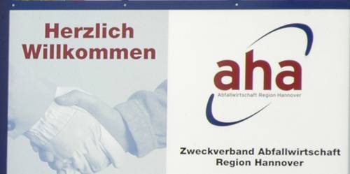 Schild mit der Aufschrift "Herzlich Willkommen" und dem Logo der von "aha"