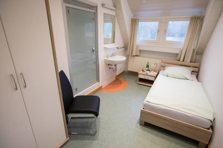 Einzelzimmer Lehrer unter Dachschräge und Waschbecken und Dusche im Zimmer
