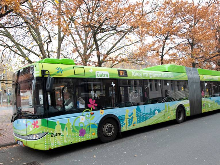 Linienbus - Hybrid-Gelenkbus, grün mit stilisierten Blüten und Landschaften 