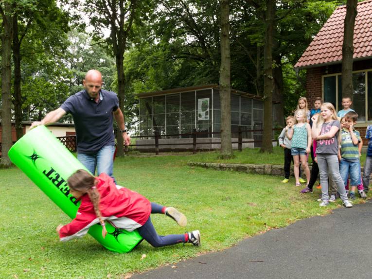 Ein Mädchen schmeisst sich an einen Rugby-Dummy.